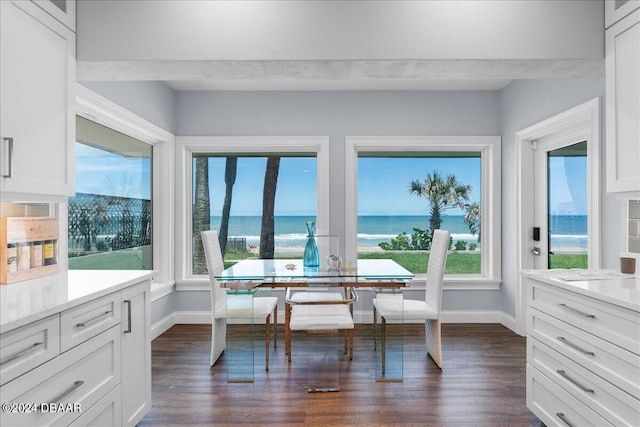 sunroom featuring a water view