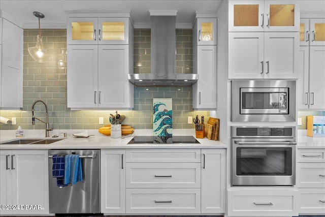 kitchen featuring white cabinets, decorative backsplash, wall chimney exhaust hood, and stainless steel appliances