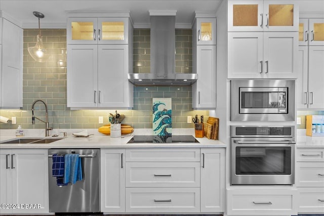 717 Ocean Shore Blvd, Ormond Beach, FL 32176 - kitchen with appliances with stainless steel finishes, wall chimney range hood, a sink, white cabinetry, and ornamental molding