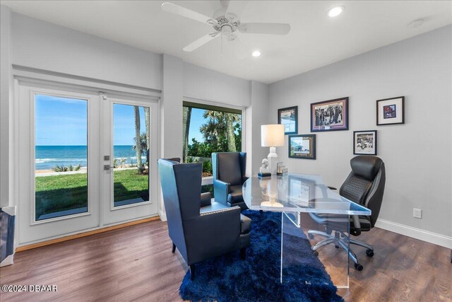 office area with ceiling fan, a water view, french doors, and dark hardwood / wood-style floors