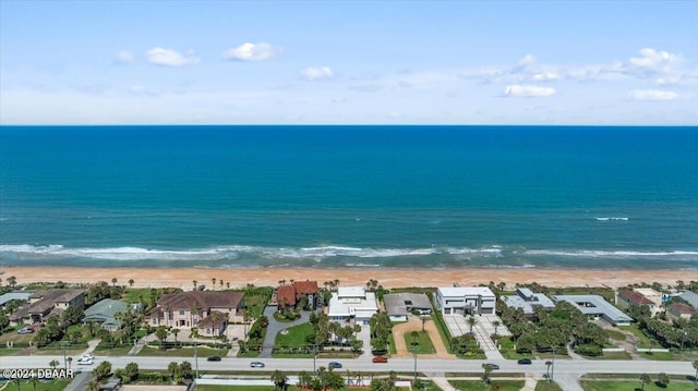 birds eye view of property with a water view and a beach view