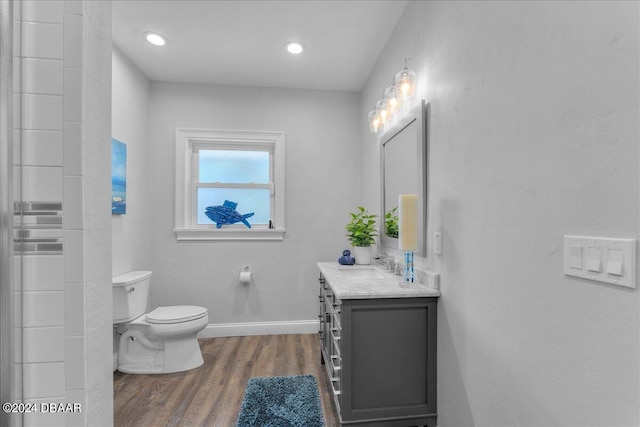 bathroom with toilet, vanity, and wood-type flooring