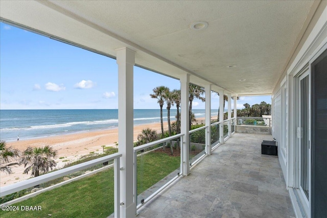 exterior space with a view of the beach, a healthy amount of sunlight, and a water view