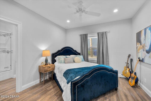 bedroom featuring ensuite bathroom, dark wood-type flooring, and ceiling fan