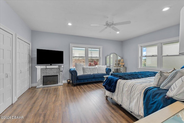 bedroom featuring dark hardwood / wood-style flooring, two closets, and ceiling fan