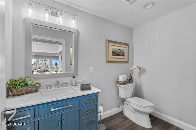 717 Ocean Shore Blvd, Ormond Beach, FL 32176 - bathroom featuring toilet, wood finished floors, baseboards, and vanity
