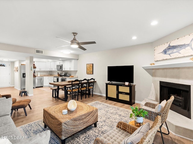 4795 S Atlantic Ave Unit 15, Ponce Inlet, FL 32127 - living room with a ceiling fan, light wood-style flooring, a tiled fireplace, and recessed lighting