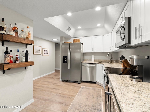 4795 S Atlantic Ave Unit 15, Ponce Inlet, FL 32127 - kitchen featuring stainless steel appliances, white cabinetry, light wood-style floors, light stone countertops, and recessed lighting