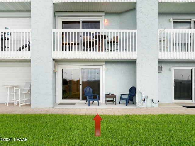 4795 S Atlantic Ave Unit 15, Ponce Inlet, FL 32127 - rear view of property with stucco siding, a balcony, a patio area, and a yard