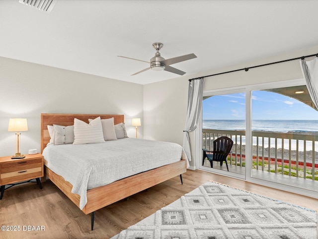 4795 S Atlantic Ave Unit 15, Ponce Inlet, FL 32127 - bedroom with access to outside, view of water and beach, wood finished floors, and a ceiling fan