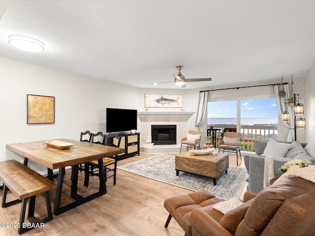 4795 S Atlantic Ave Unit 15, Ponce Inlet, FL 32127 - living area with a ceiling fan, light wood-type flooring, and a fireplace