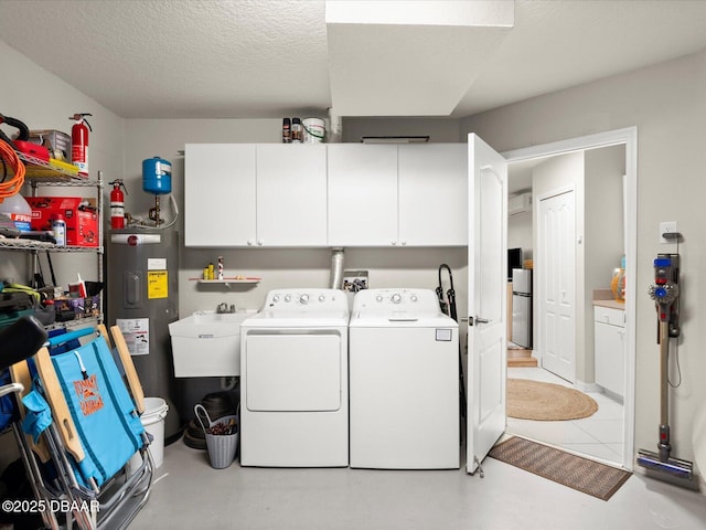4795 S Atlantic Ave Unit 15, Ponce Inlet, FL 32127 - laundry area featuring water heater, washing machine and dryer, cabinet space, and a textured ceiling