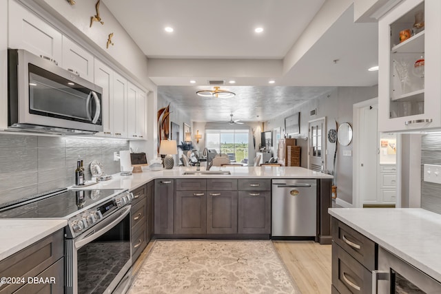 kitchen with light wood-type flooring, white cabinetry, sink, and stainless steel appliances