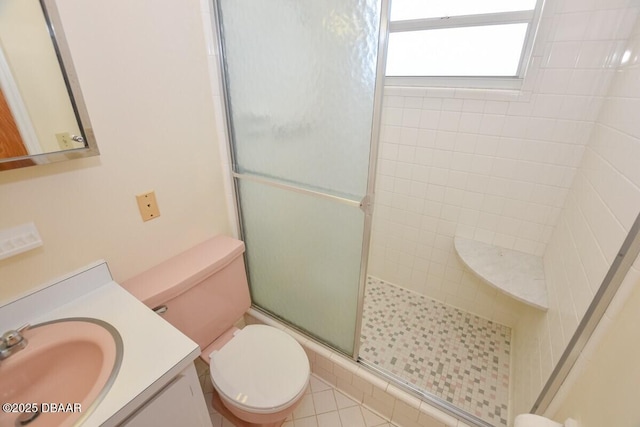 bathroom with a shower with door, vanity, and toilet