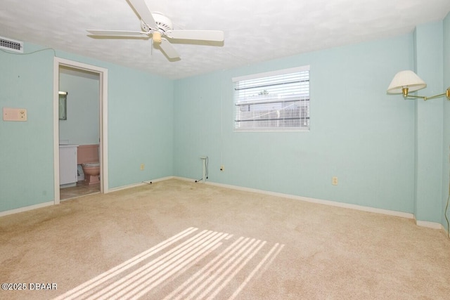 interior space with light carpet, ceiling fan, and ensuite bathroom