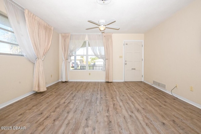 empty room with ceiling fan and light hardwood / wood-style flooring