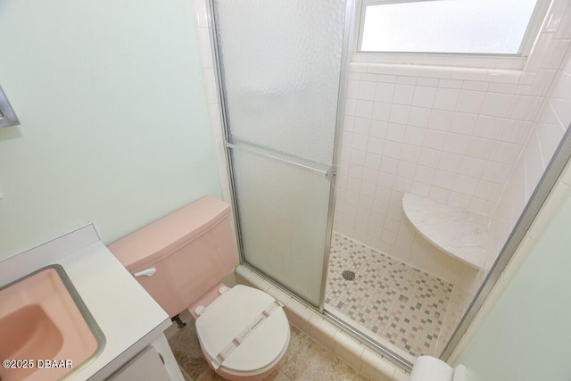 bathroom featuring vanity, toilet, and a shower with shower door