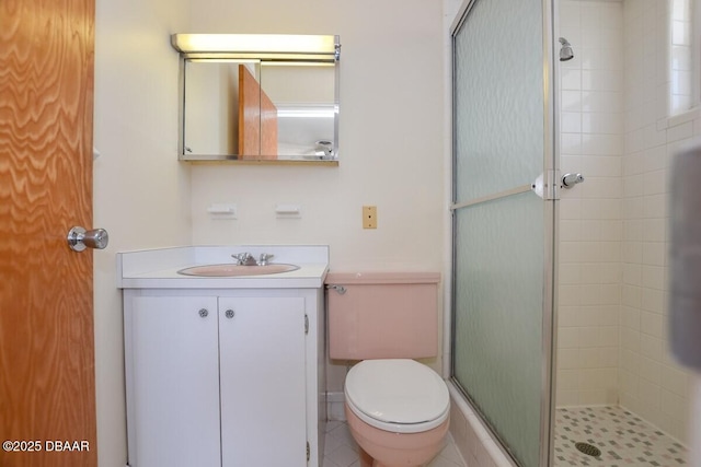 bathroom with vanity, a shower with shower door, and toilet