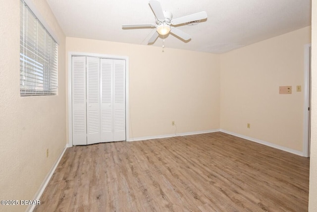 unfurnished bedroom featuring light hardwood / wood-style flooring, a closet, and ceiling fan