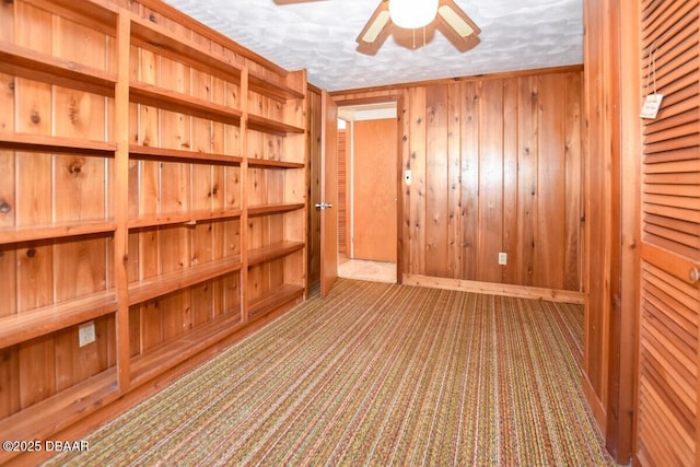 interior space featuring ceiling fan and wooden walls