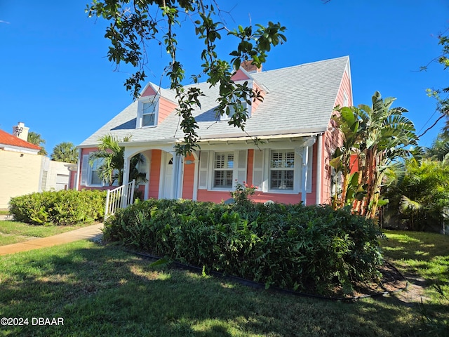 cape cod house with covered porch and a front lawn