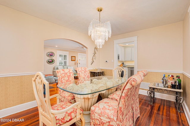 dining space featuring dark hardwood / wood-style floors, crown molding, and a chandelier