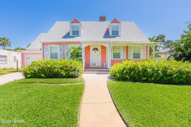 cape cod home with a garage and a front lawn