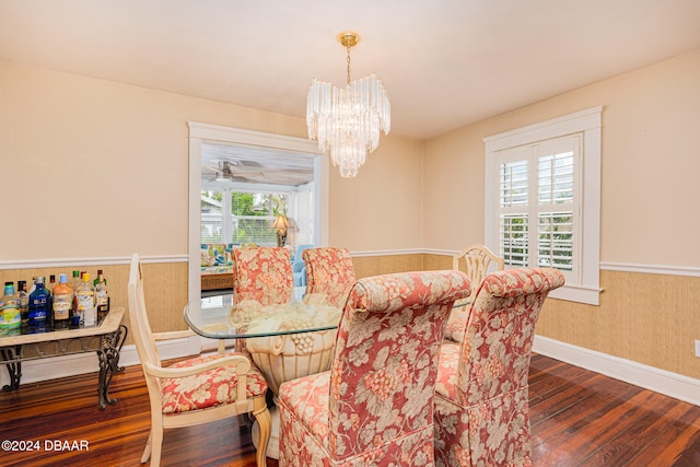 dining space featuring ceiling fan with notable chandelier, dark wood-type flooring, and a healthy amount of sunlight