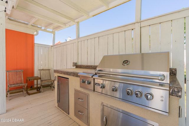 view of patio with an outdoor kitchen, a deck, and grilling area