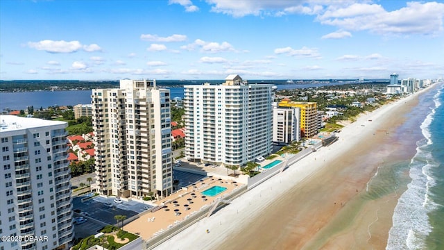 drone / aerial view with a city view, a view of the beach, and a water view