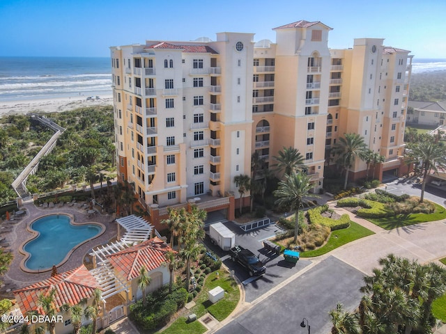 view of building exterior featuring a community pool and a water view