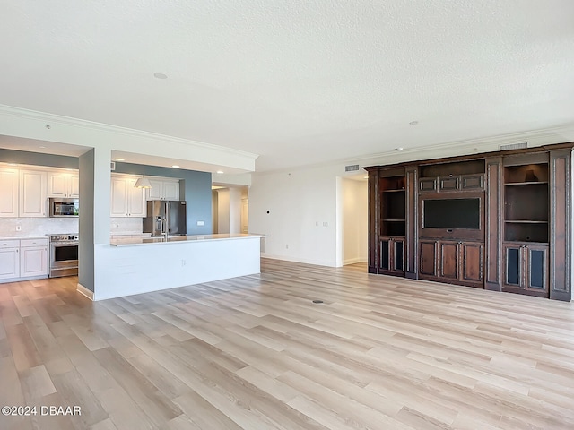 unfurnished living room featuring crown molding, light hardwood / wood-style flooring, and a textured ceiling