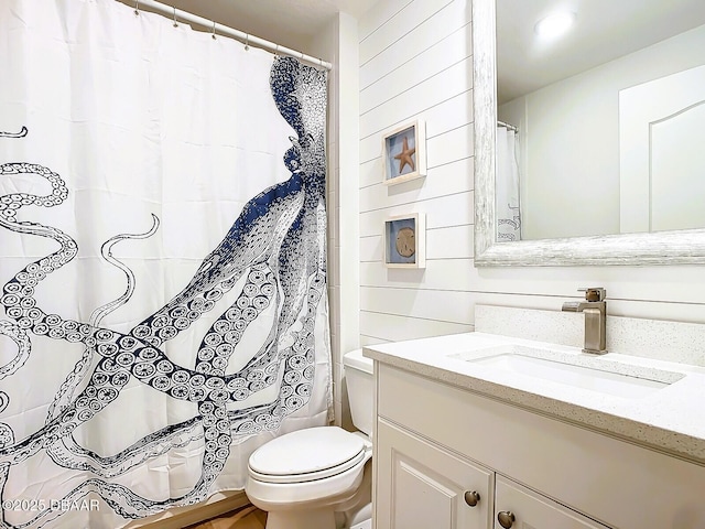 full bathroom featuring a shower with shower curtain, toilet, and vanity