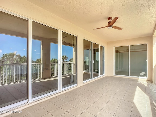 unfurnished sunroom featuring ceiling fan