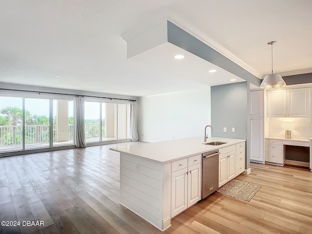 kitchen featuring a center island with sink, white cabinetry, stainless steel dishwasher, and decorative light fixtures