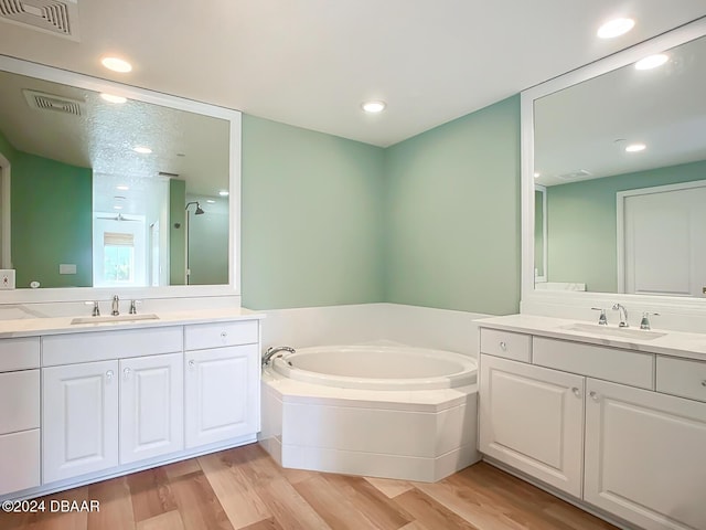 bathroom featuring hardwood / wood-style flooring, vanity, and separate shower and tub