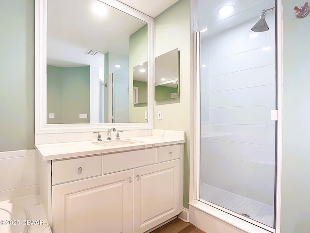 full bath with visible vents, a stall shower, and vanity