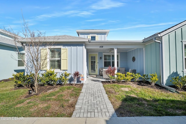 entrance to property featuring a yard and covered porch