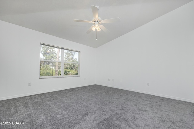 spare room with dark carpet, baseboards, ceiling fan, and vaulted ceiling
