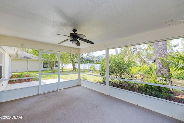 unfurnished sunroom with plenty of natural light and a ceiling fan