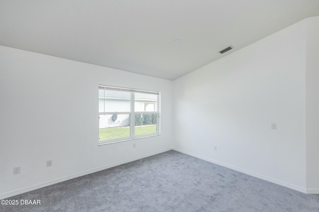 unfurnished room featuring baseboards, carpet flooring, lofted ceiling, and visible vents