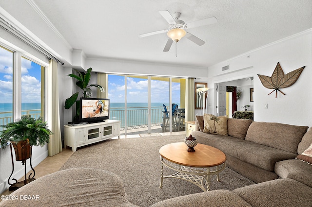 living room featuring ceiling fan, a textured ceiling, light tile patterned floors, and ornamental molding