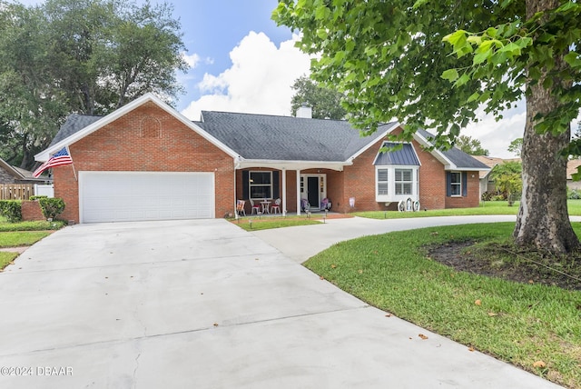 single story home featuring driveway, a front lawn, and brick siding