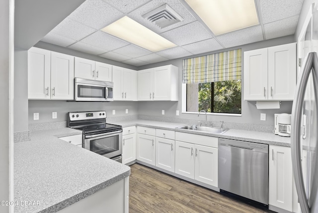 kitchen featuring stainless steel appliances, light countertops, a sink, and visible vents