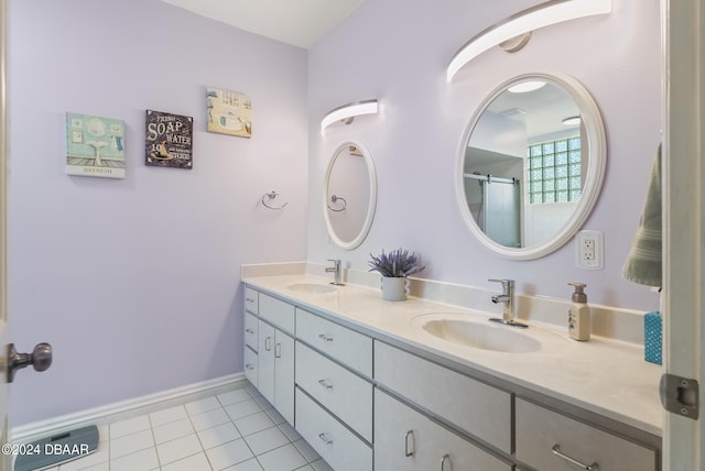 bathroom featuring double vanity, baseboards, a sink, and tile patterned floors