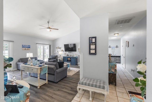 living area with visible vents, baseboards, ceiling fan, vaulted ceiling, and french doors