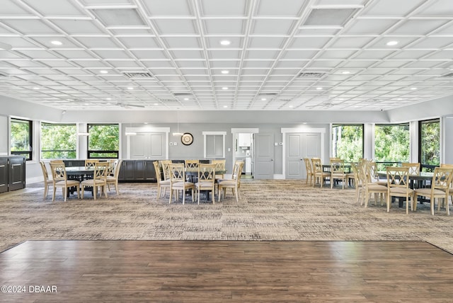 unfurnished dining area featuring a healthy amount of sunlight, visible vents, and wood finished floors