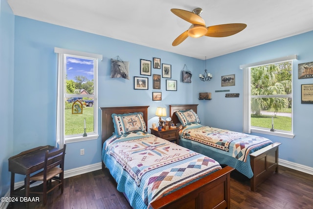 bedroom with dark wood-style floors, ceiling fan, and baseboards