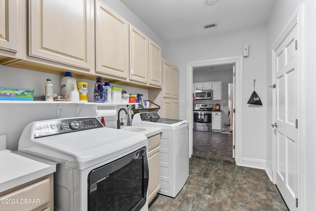 washroom with separate washer and dryer, visible vents, baseboards, cabinet space, and stone finish flooring