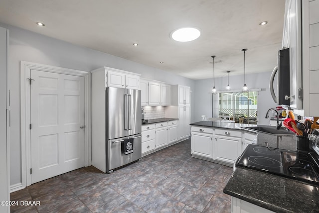 kitchen with a peninsula, high quality fridge, white cabinetry, and tasteful backsplash